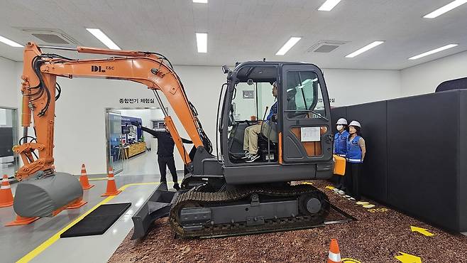 굴삭기와 벽체 사이에 근로자가 협착되는 상황을 연출한 모습. [고은결 기자]