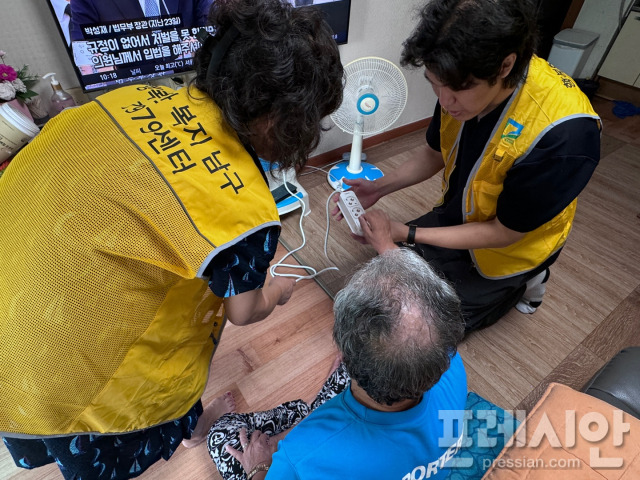 ▲7979봉사단원들이 방문 가정에 멀티탭을 설치하고 있다ⓒ광주 남구