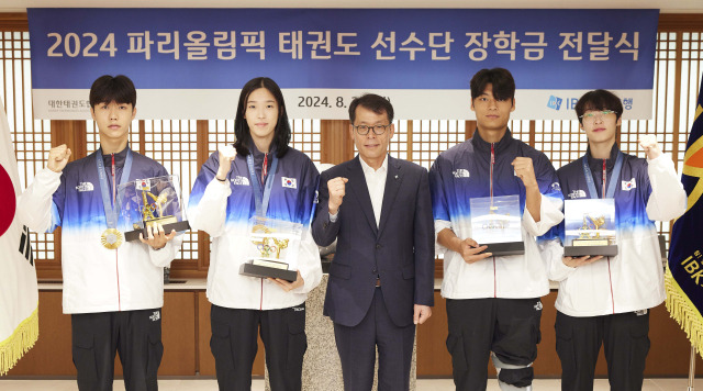 김성태(가운데) IBK기업은행장이 26일 서울 중구 기업은행 본점에서 열린 ‘2024 파리올림픽 태권도선수단 장학금 전달식’에서 태권도 선수단과 함께 기념 촬영을 하고 있다. 사진 제공=IBK기업은행