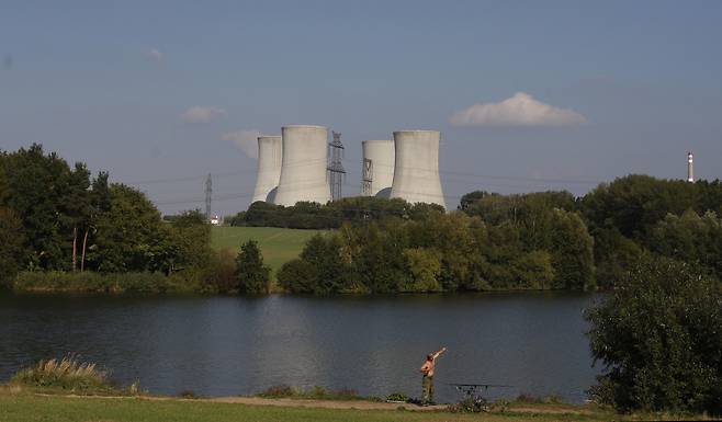 A man fishes with the towering Dukovany nuclear power plant in the background, in Dukovany, Czech Republic, Sept. 27, 2011. [AP/YONHAP]