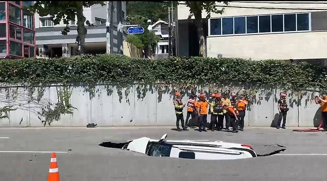 29일 오전 서울 서대문구 연희동 성산로에서 땅 꺼짐 사고로 승용차가 빠져 있다. 이 사고로 승용차 탑승자들이 병원으로 후송됐다. 연합뉴스