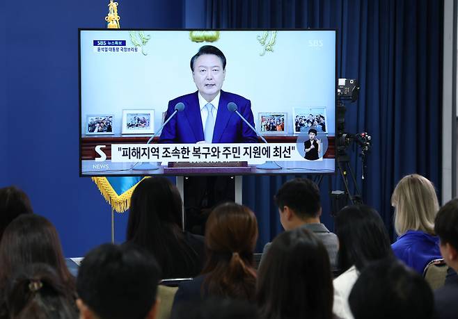 29일 오전 서울 용산 대통령실 청사 브리핑룸에서 취재진이 생방송으로 중계되는 윤석열 대통령의 ‘국정브리핑’을 지켜보고 있다. [연합뉴스]