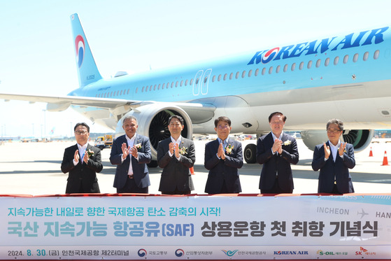 From left, President of SK Energy Oh Jong-hoon, CEO of S-Oil Anwar Al-Hejazi, Minister of Trade, Industry and Energy Ahn Duk-geun, Minister of Land, Infrastructure and Transport Park Sang-woo, President of Korean Air Woo Kee-hong and President of Incheon International Airport Corporation Lee Hak-jae pose for a photo at an event celebrating the first commercial launch of flight using domestic sustainable aviation fuel at Incheon International Airport Terminal 2 on Friday. [MINISTRY OF LAND, INFRASTRUCTURE AND TRANSPORT]