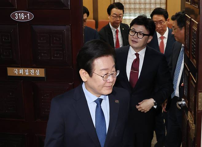 국민의힘 한동훈 대표와 더불어민주당 이재명 대표(앞쪽)가 1일 오후 국회에서 채상병 특검법, 금융투자소득세 폐지, 전 국민 25만원 지원법 등을 논의하는 여야 대표 회담을 마친 뒤 나오고 있다. /연합뉴스