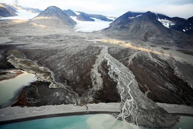 노르웨이 스발바르 제도의 스베아 지역이 시커먼 맨살을 드러내고 있다. 한때 눈부시게 빛났던 이 지역의 빙하는 산꼭대기 등에 일부만 남아있다. 빙하가 녹아내린 흔적에서는 북극의 신음이 들리는 듯하다. 지난달 5일 스발바르 롱위에아르뷔엔에서 북극 다산기지가 있는 니알슨으로 가는 비행기에서 찍은 모습이다. 빙하로 뒤덮였던 영구동토층은 처참한 얼굴로 기후위기를 온몸으로 외치고 있다.