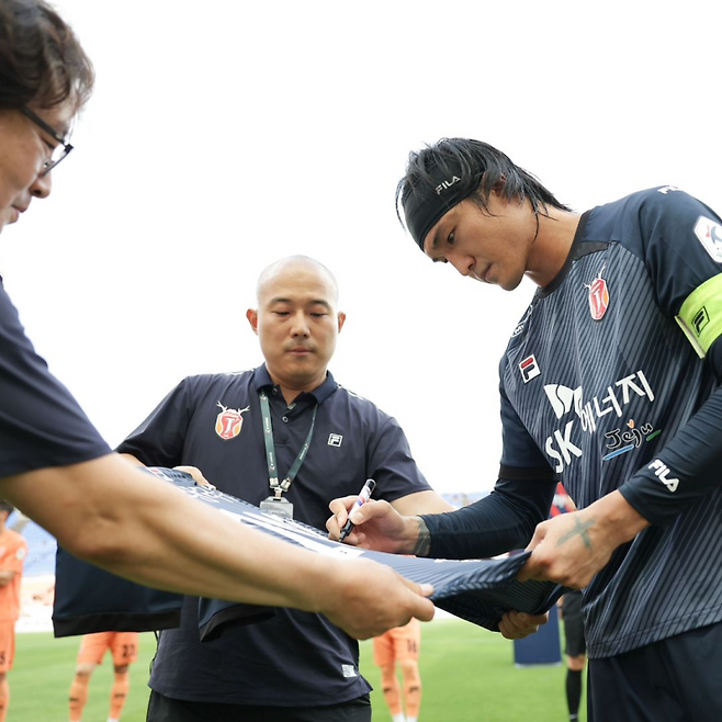김동준(오른쪽)이 1일 소속팀 제주와 2029년까지 계약을 연장한 뒤 기념 유니폼에 사인을 하고 있다. 그는 이날 제주월드컵경기장에서 열린 김천 상무와의 경기에서 선방 쇼를 펼치며 팀의 승리를 이끌었다. 사진=제주