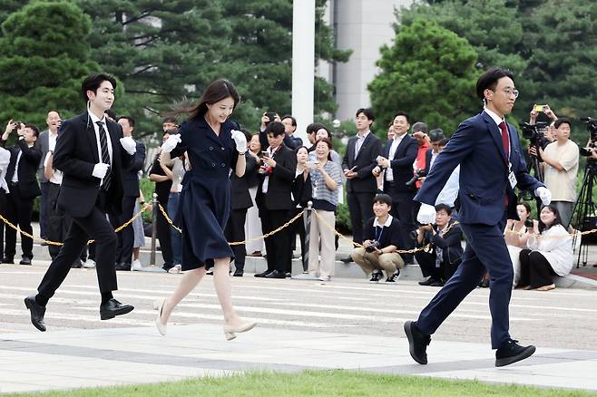 국회 직원들이 손을 맞잡는 포즈를 시연한 뒤 촬영을 위해 빠르게 이동하고 있다.