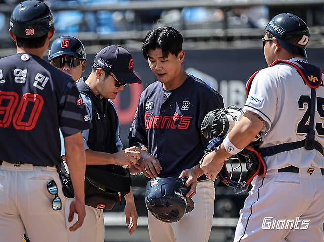 ▲ 롯데 손호영이 1일 서울 잠실구장에서 열린 2024 신한 SOL뱅크 KBO 리그 두산과의 경기에서 1회초 조던 발라조빅의 시속 149km 강속구에 오른 손등을 맞고 트레이너와 상태를 체크하고 있다. ⓒ 롯데 자이언츠