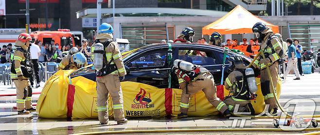 28일 서울 성동구 왕십리광장에서 열린 성동구, 성동소방서와 전기차 화재 대응 합동 훈련에서 소방관들이 불이난 전기차에 포켓식 소화 수조를 설치하고 있다.(사진은 기사 내용과 무관함) 2024.8.28/뉴스1 ⓒ News1 박지혜 기자