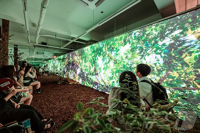 서울 성수동 연무장길에서 열린 ‘디지털 치유정원’ 팝업 전시에 참석한 한국수목원정원관리원 심상택 이사장(왼쪽 두 번째)이 전시를 관람하고 있다.(한국수목원정원관리원 제공) /뉴스1