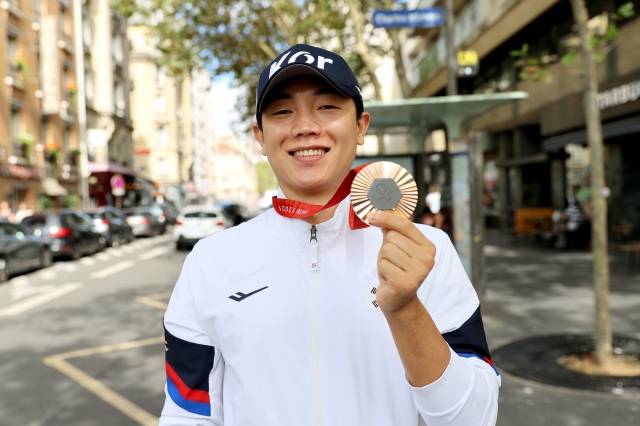 주정훈이 2일(현지시간) 프랑스 파리 시내의 한 카페에서 인터뷰를 마친 뒤 동메달을 든 채 포즈를 취하고 있다. 대한장애인체육회 제공
