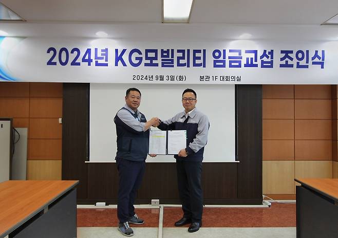 박장호 KGM 대표이사와 (왼쪽)선목래 KGM 노동조합 위원장이 2024년 임금협상 조인식에서 합의안에 대한 서명 후 기념 촬영을 하는 모습.