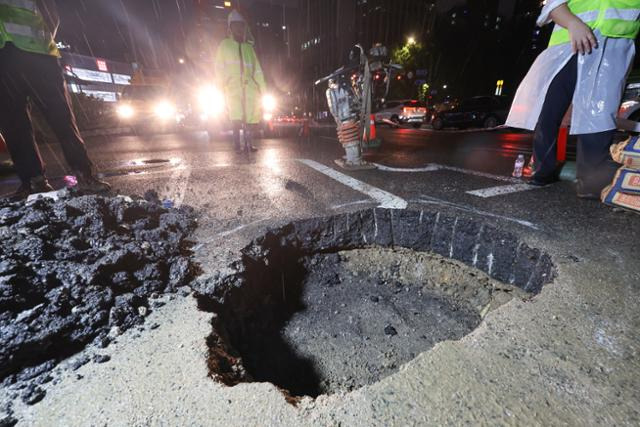 지난 7월 20일 오후 서울 지하철 3호선 경복궁역에서 사직터널 방향으로 가는 사직로에 도로파임(포트홀)이 발생해 복구 작업이 이뤄지고 있다. 연합뉴스