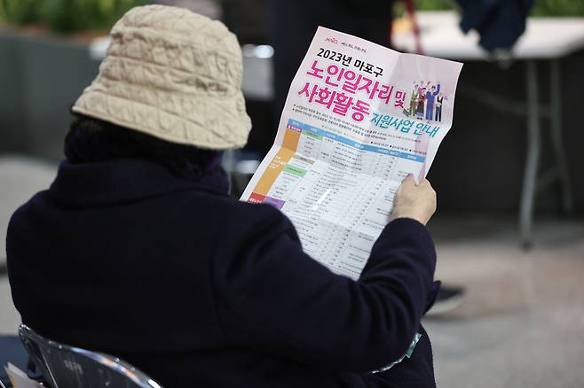 한 시민이 서울 마포구청에서 열린 노인 일자리 박람회에서 안내문을 읽고 있다. 연합뉴스