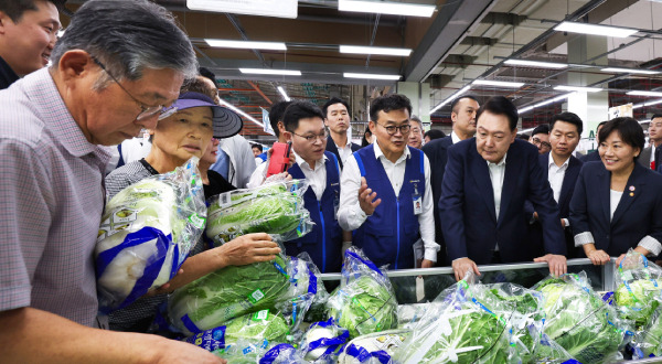 President Yoon Suk-yeol visits NH Hanaro Mart in Seoul and listens to officials near the cabbage display ahead of Chuseok. [Courtesy of the Office of the President]