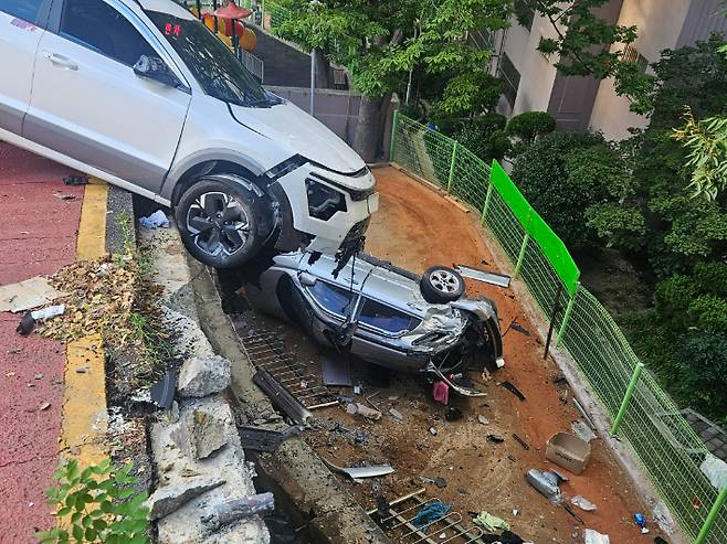 지난 3일 오후 5시 30분쯤 택시가 주차된 차량을 들이받아 차량이 5m 아래로 추락하는 사고가 발생했다. 부산소방재난본부 제공