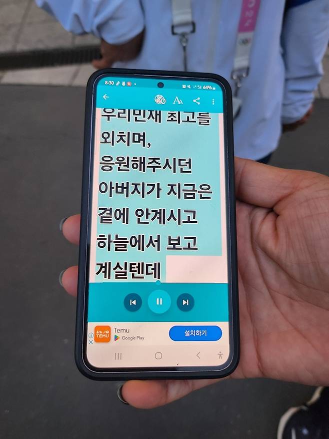 육상 대표팀 전민재가 5일(한국시간) 프랑스 파리 스타드 드 프랑스에서 열린 2024 파리 패럴림픽대회 육상 여자 100m(스포츠 등급 T36) 결선을 마친 후 취재진을 만났다. 스마트폰을 통해 준비한 편지를 보여주고 있다. 사진 | 대한장애인체육회