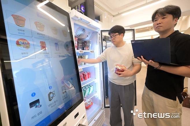 서울 강남구 비버웍스 본사 쇼룸에서 연구원이 비전센싱 기술로 냉장고 밖으로 꺼낸 제품을 자동으로 키오스크에서 인식하는 스마트밴딩머신의 기능을 테스트하고 있다. 김민수기자 mskim@etnews.com