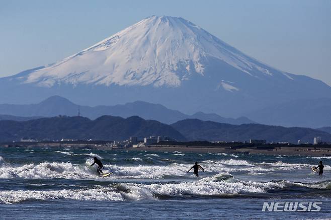 [가나가와(일본)=AP/뉴시스]일본 후지산(富士山) 대규모 분화로 수도권에 대량의 화산재가 광범위하고 긴 시간 동안 내릴 가능성에 대비해 기상청이 예보 시스템인 '광역강회예보'를 도입할 방침을 굳혔다고 5일 요미우리신문이 보도했다. 사진은 2021년 2월 19일 가나가와현 후지사와시에서 서퍼들이 후지산을 바라보며 파도를 타고 있는 모습. 2024.09.05.