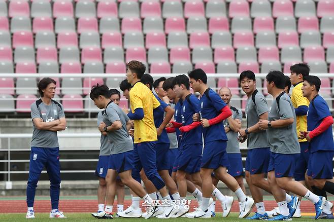 홍명보 축구대표팀 감독(왼쪽)과 코치스태프가 지난 2일 고양종합운동장에서 진행된 대표팀 훈련에서 달리기로 몸을 푸는 선수들을 지켜보고 있다. 고양 | 한수빈 기자