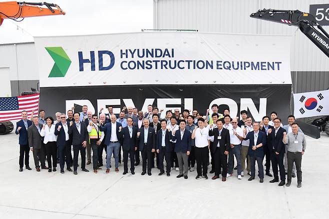 Mike Ross, senior vice president of HD Hyundai Construction Equipment North America, fourth from left in the front, poses with Moon Jae-young, chief sales officer and vice president of HD Hyundai Construction Equipment; Tommy Sidener, general manager at Wallenius Wilhelmsen; Mike Rye, senior vice president; HD Hyundai XiteSolution President Cho Young-cheul; John Felitto, chief operating officer at Wallenius Wilhelmsen; Park Chan-hyuk, vice president of HD Hyundai XiteSolution; Jeong Kwan-hee, managing director at HD Hyundai Infracore North America and other executives at the opening ceremony of an integrated customization center in Georgia on Wednesday. [HD HYUNDAI XITESOLUTION]