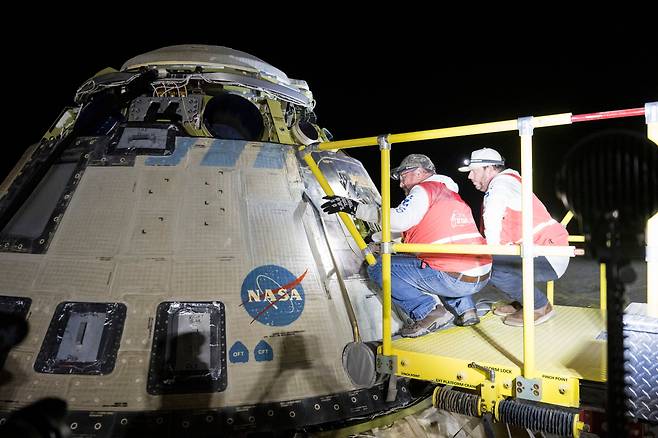 보잉과 NASA 팀이 지난 6일 국제우주정거장(ISS)에서 분리된 후 뉴멕시코주 화이트샌드에 무인으로 착륙한 NASA의 보잉 크루 비행 시험 스타라이너 우주선 주변에서 작업하고 있다./NASA, 연합뉴스