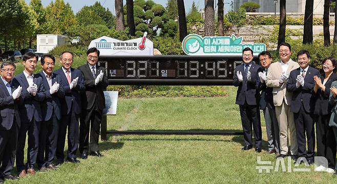 [서울=뉴시스] 조성우 기자 = 4일 오전 서울 여의도 국회 본청 앞 잔디밭에서 열린 기후위기시계 이전 제막식에서 우원식(왼쪽 다섯 번째) 국회의장과 추경호 국민의힘, 박찬대(오른쪽 다섯 번째) 더불어민주당 원내대표 등 참석자들이 기념촬영을 하고 있다. 2024.09.04. xconfind@newsis.com