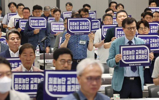 지난달  31일 서울 용산구 대한의사협회에서 열린 대한의사협회 긴급 임시대의원총회에서 참석자들이 의대 정원 증원 저지ㆍ필수의료 패키지 대응ㆍ간호법 저지를 위한 투쟁 선포식을 하며 손팻말을 들고 있다. 연합뉴스