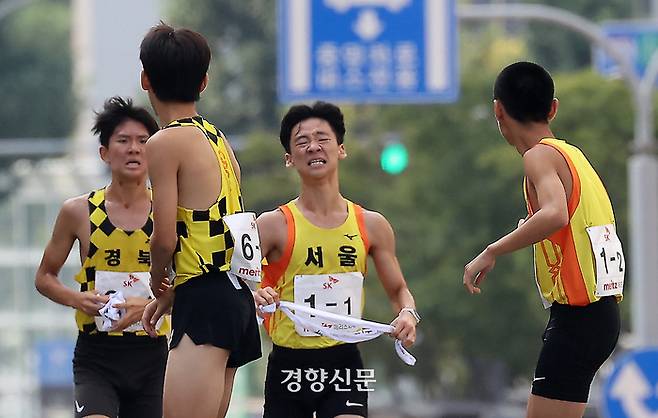 제54회 대통령기 전국통일구간마라톤대회가 열린 8일 서울 중구 경향신문사 앞에서 출발한 선수들이 서대문구 무악재를 지나 다음 주자에게 배턴을 전달하고 있다.