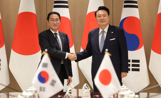 Korean President Yoon Suk Yeol, right, and Japanese Prime Minister Fumio Kishida shake hands during their summit in Seoul on Friday. [JOINT PRESS CORPS]