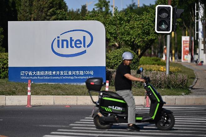 중국 랴오닝성 다롄에 위치한 인텔의 웨이퍼 제조 공장 앞을 한 시민이 지나가고 있다. (사진=AFP)