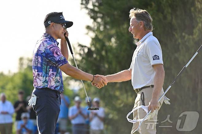 PGA 챔피언스 투어 우승을 차지한 양용은(왼쪽)이 랑거와 악수를 하고 있다. ⓒ AFP=뉴스1