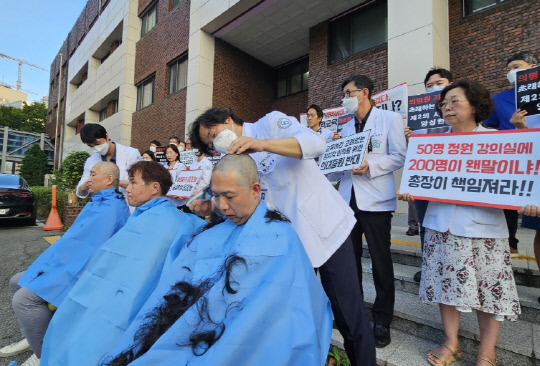 정부의 의대 정원 증원 정책을 반대하는 의대 교수들이 9일 충북대 의대 본관 앞에서 삭발과 단식 투쟁을 하는 모습. 연합뉴스