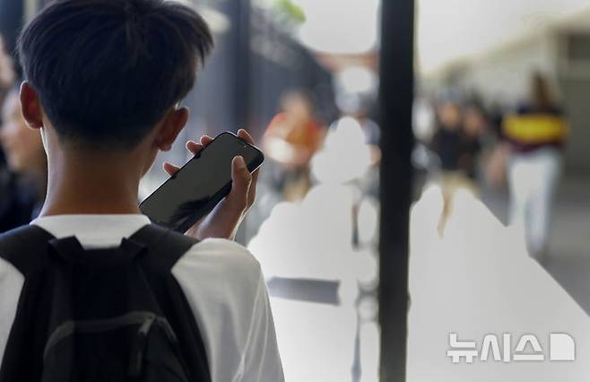 [산마테오=AP/뉴시스]유럽 곳곳에서 학교 안 휴대전화 사용을 금지하거나 줄이는 방안을 시행하고 있다. 자유권을 제한한다는 일부 비판에도 이 같은 조치가 학생 정신 건강과 집중력에 긍정적 영향을 미치고 있는 것으로 나타났다. 가디언은 9일(현지시각) 지난 1월 대부분 지역 중학교 교실에서 휴대전화, 태블릿 컴퓨터, 스마트워치 사용을 금지하도록 권고한 네덜란드 사례를 조명했다. 사진은 한 학생이 지난달 16일 미국 캘리포니아주 산마테오의 한 학교에서 수업이 끝난 뒤 휴대전화를 사용하는 모습. 2024.09.09.