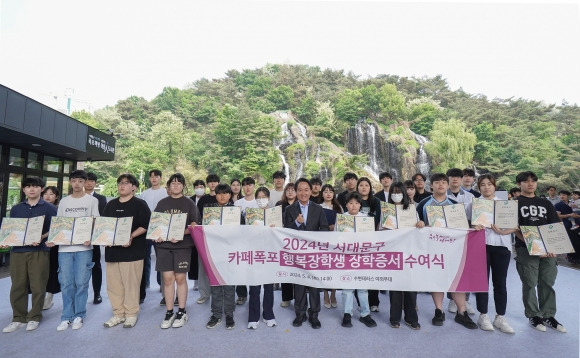 이성헌 서대문구청장(앞줄 왼쪽 일곱 번째)이 지난 5월 4일 서대문 홍제폭포 광장에서 열린 ‘카페 폭포 행복장학금’ 수여식 후 장학생들과 함께 기념 촬영을 하고 있다. 서대문구 제공