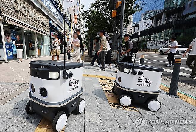 자율주행 로봇 배달 시연 (성남=연합뉴스) 홍기원 기자 = 9일 오후 경기도 성남시 판교역 일대에서 도심형 자율주행 로봇배달 서비스 시연이 진행되고 있다. 
    자율주행 로봇 배달 서비스는 중소상공인 일부 상점에서 주문이 들어오면 배달 로봇이 상품을 적재한 후 자율주행으로 목적지까지 이동해 주문 고객에게 전달하고 출발지까지 자동복귀 후 종료되는 시나리오로 구성된다. 2024.9.9 xanadu@yna.co.kr