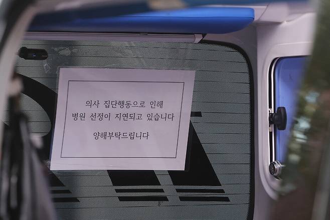 지난 9일 오전 서울 시내 한 병원 응급의료센터에 주차된 구급차에 ‘의사 집단행동으로 인해 병원 선정이 지연되고 있다\\\'는 안내문이 붙어 있다. 연합뉴스