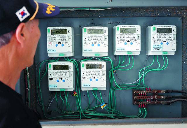 한국전력은 지난달 가구당 평균 전기 요금이 6만3610원으로 전년 동월보다 7520원(13%) 올라 고지된다고 9일 밝혔다. 역대급 폭염으로 냉방용 전기 수요가 늘어서다. 사진은 이날 서울시내 한 빌라에서 관계자가 전기계량기를 살펴보는 모습. 연합뉴스