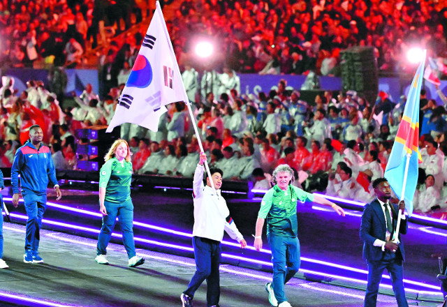 한국 대표팀 기수 최용범(가운데)이 8일(현지시간) 프랑스 파리의 스타드 드 프랑스에서 열린 2024 파리 패럴림픽 폐회식에서 태극기를 들고 입장하고 있다. 사진공동취재단