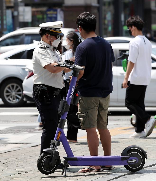 서울 마포구 홍대입구역 인근에서 경찰이 헬멧 미착용 등 개인형 이동장치 위반을 단속하는 모습. <김호영기자>