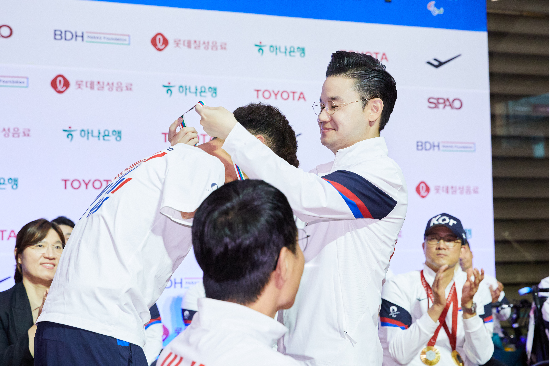 배동현 선수단장이 트라이애슬론 김황태 선수에게 순금메달을 수여하고 있다