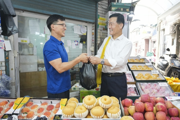 이승로(오른쪽) 서울 성북구청장이 지난 10일 장위전통시장에서 성북사랑상품권을 이용해 과일을 구매하고 있다.   성북구 제공