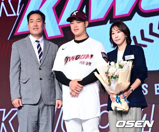 [OSEN=지형준 기자] 11일 오후&nbsp;서울 잠실 롯데호텔 월드에서 2025 KBO 신인 드래프트가 열렸다.2025 KBO&nbsp;신인 드래프트는 전면 드래프트 방식으로 진행된다. 지명은 1라운드부터 11라운드까지 이뤄지며, 2023년도 구단 순위의 역순인 키움-한화-삼성-롯데-KIA-두산-NC-SSG-KT-LG 순서로 실시된다.덕수고 정현우가 전체 1순위로 키움에 지명되며 고형욱 단장, 어머니와 포즈를 취하고 있다. 2024.09.11 / jpnews@osen.co.kr