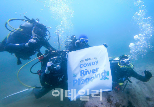 코웨이 임직원 자원봉사단이 강원도 고성 송지호해변 바다에서 수중 쓰레기를 수거하고 있다. (사진=코웨이)