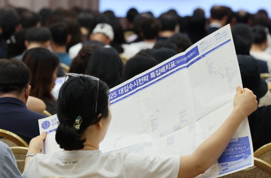 지난 7월 서울 광진구 세종대학교 컨벤션센터에서 열린 대입 설명회에서 학부모와 학생들이 입시 자료를 살피고 있다. 뉴스1