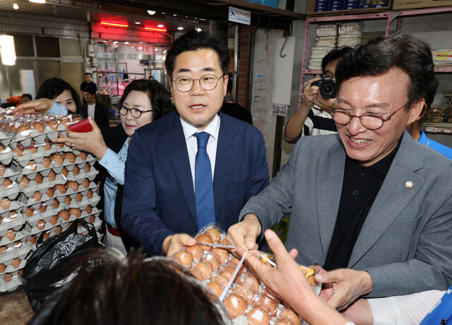 박찬대 더불어민주당 원내대표와 김민석 최고위원 등이 지난달 30일 오후 전남 영광터미널시장을 찾아 달걀을 구매하고 있다. 연합뉴스