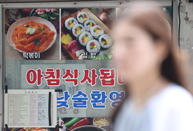 11일 오전 서울 시내 한 식당에 김밥을 포함한 메뉴판 앞을 한 시민이 지나치고 있다. 연합뉴스