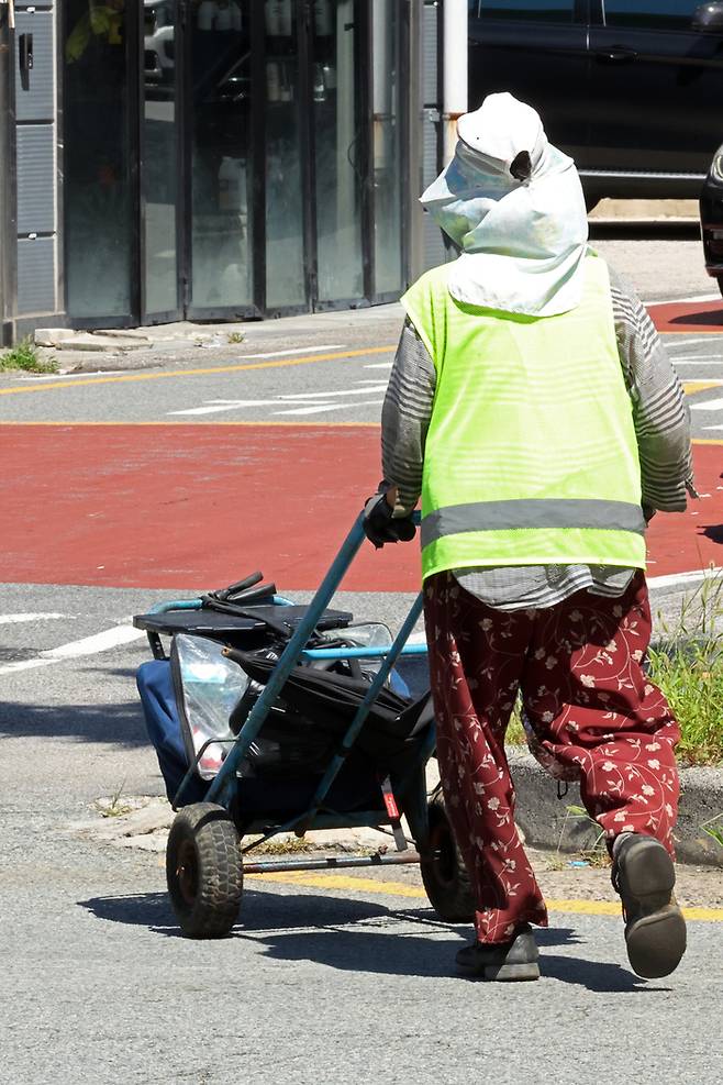 도로에서 폐지 수집 노인이 수레를 끌고 이동하고 있다. 연합뉴스