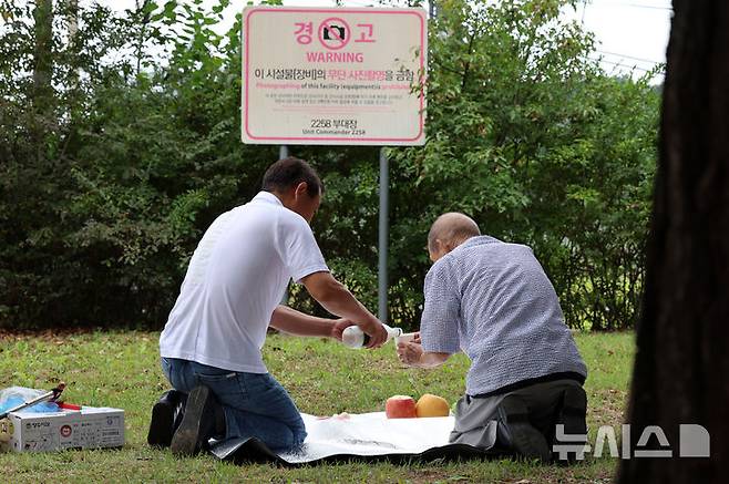 [파주=뉴시스] 이영환 기자 = 추석인 17일 오전 경기 파주시 임진각에서 실향민 홍관섭씨와 아들이 북녘을 향해 잔을 올리고 있다. 2024.09.17. 20hwan@newsis.com