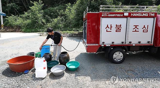 폭염 속 단수 (청도=연합뉴스) 윤관식 기자 = 5일 경북 청도군 풍각면 한 가정집이 단수된 가운데 풍각면사무소 직원이 급수 지원을 하고 있다.
  청도군은 전체 물 사용량이 생산량을 넘어서면서 전날 오후부터 일부 지역에서 물을 사용하지 못하고 있다. 2024.8.5 psik@yna.co.kr